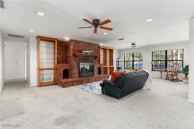 living room with carpet, ceiling fan, and a fireplace