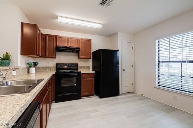 kitchen with sink, light hardwood / wood-style floors, and black appliances