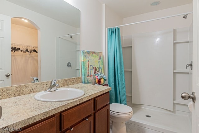 bathroom featuring vanity, curtained shower, and toilet