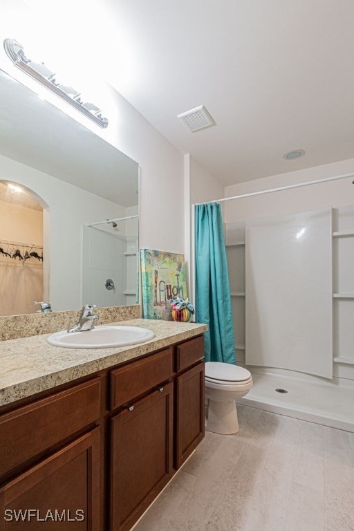 bathroom with vanity, a shower with shower curtain, and toilet