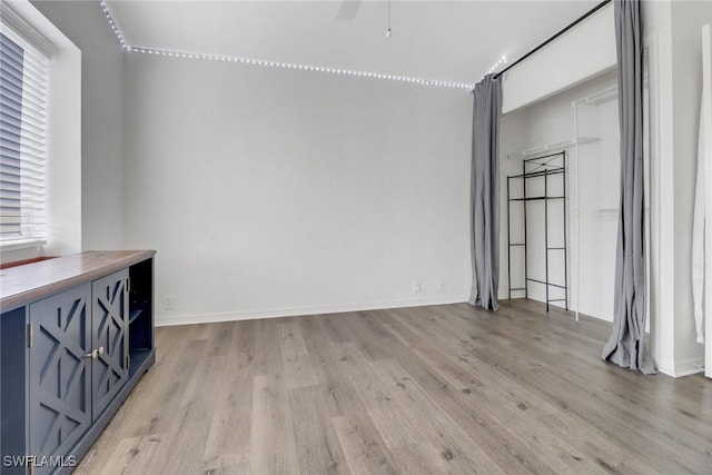 interior space with ceiling fan, a wealth of natural light, and light hardwood / wood-style floors