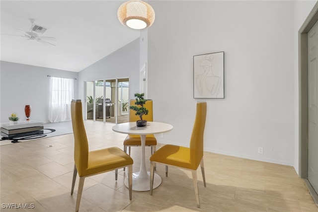 dining area with light tile patterned flooring, ceiling fan, and high vaulted ceiling