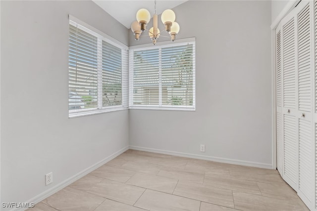 interior space featuring light tile patterned flooring, plenty of natural light, and a notable chandelier