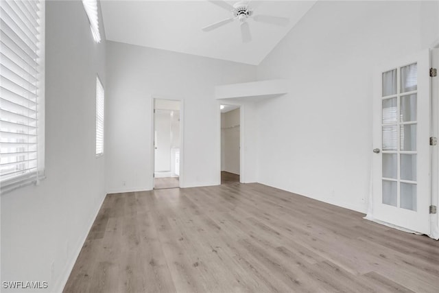 unfurnished living room with high vaulted ceiling, light hardwood / wood-style floors, and ceiling fan