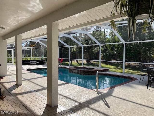 view of pool featuring a patio, glass enclosure, and an in ground hot tub