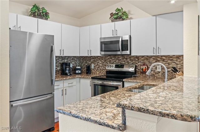 kitchen featuring white cabinets, kitchen peninsula, backsplash, and appliances with stainless steel finishes