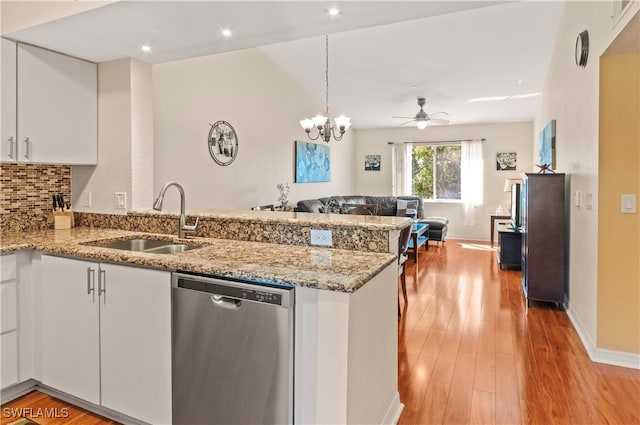 kitchen with dishwasher, sink, kitchen peninsula, white cabinets, and ceiling fan with notable chandelier