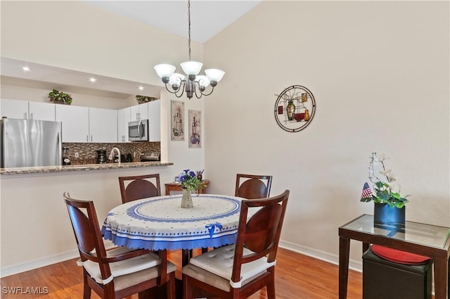 dining room with a chandelier, light hardwood / wood-style flooring, and sink