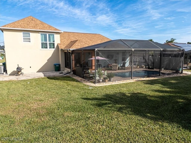 rear view of property featuring glass enclosure and a yard