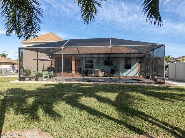 back of house featuring a lanai, a patio area, and a yard