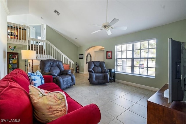 living room with ceiling fan, light tile patterned floors, and vaulted ceiling