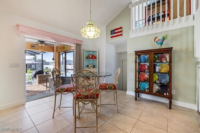 dining area featuring ceiling fan, light tile patterned flooring, and high vaulted ceiling