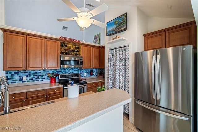 kitchen featuring ceiling fan, stainless steel appliances, backsplash, vaulted ceiling, and light tile patterned floors