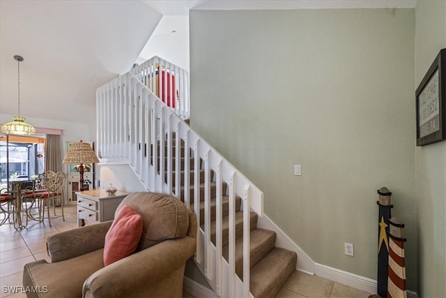 stairway with vaulted ceiling and tile patterned floors