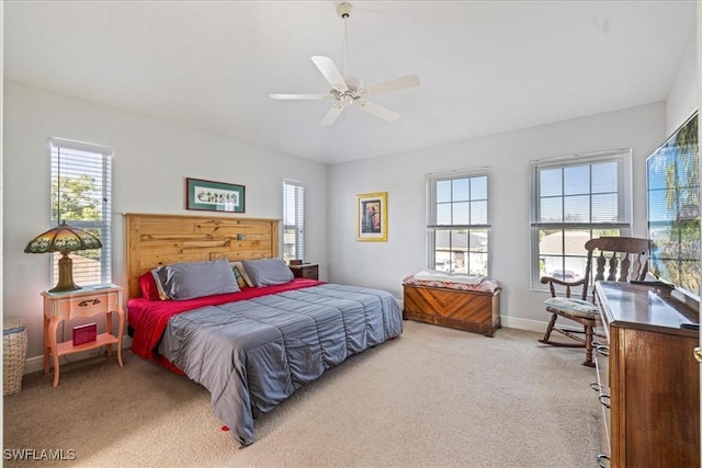 bedroom featuring multiple windows, ceiling fan, and carpet