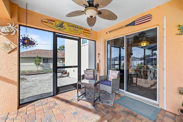 sunroom / solarium featuring ceiling fan