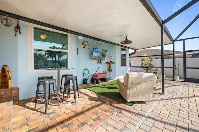 view of patio / terrace featuring ceiling fan and a lanai