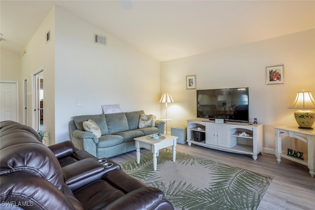 living room with vaulted ceiling and light wood-type flooring