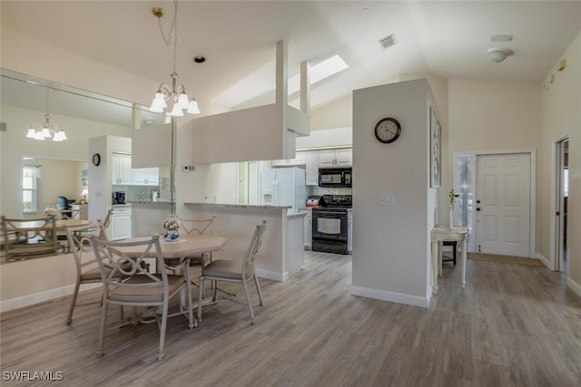 dining space with light wood-type flooring, high vaulted ceiling, and a notable chandelier