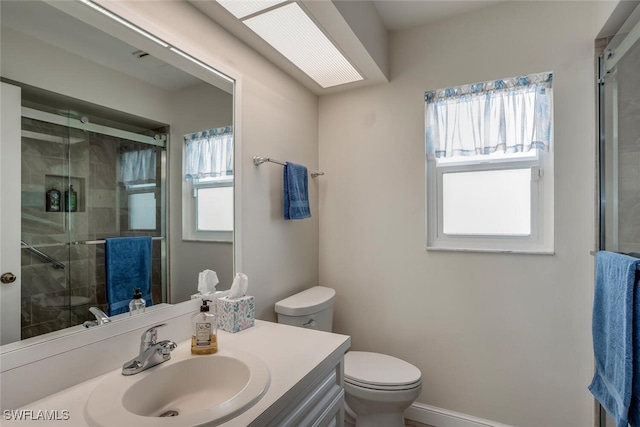 bathroom with vanity, toilet, and a shower with door