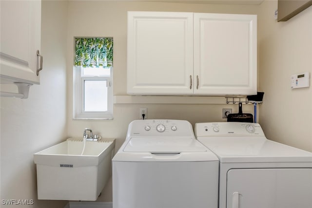 laundry area featuring cabinets, independent washer and dryer, and sink