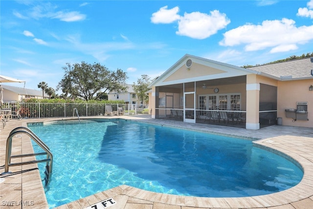 view of pool with a sunroom and a patio area