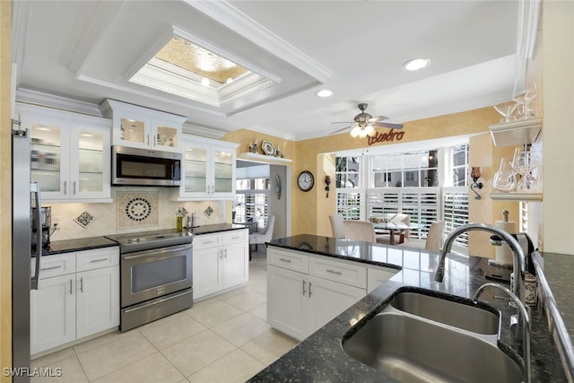 651 Wiggins Lake Dr Unit 101, Naples, FL 34110 - kitchen with appliances with stainless steel finishes, decorative backsplash, light tile patterned floors, white cabinets, and ornamental molding