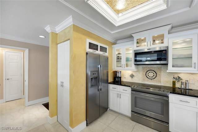 651 Wiggins Lake Dr Unit 101, Naples, FL 34110 - kitchen featuring appliances with stainless steel finishes, white cabinetry, decorative backsplash, dark stone counters, and crown molding