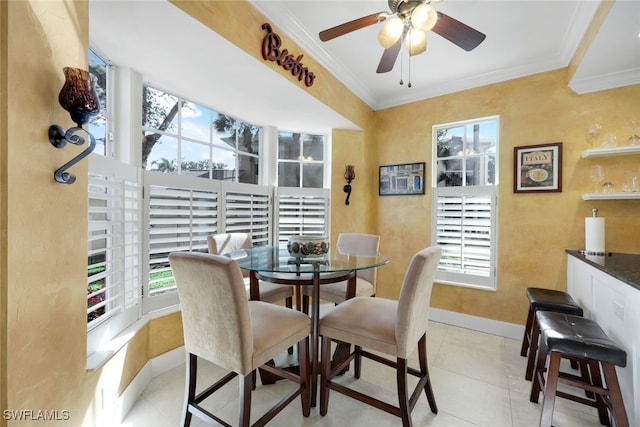 dining area with ceiling fan, light tile patterned flooring, and crown molding