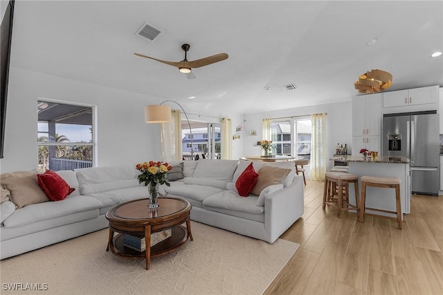 living room with ceiling fan and light hardwood / wood-style flooring