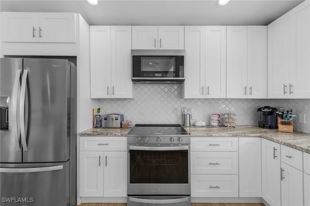 kitchen featuring white cabinetry, stainless steel appliances, and backsplash