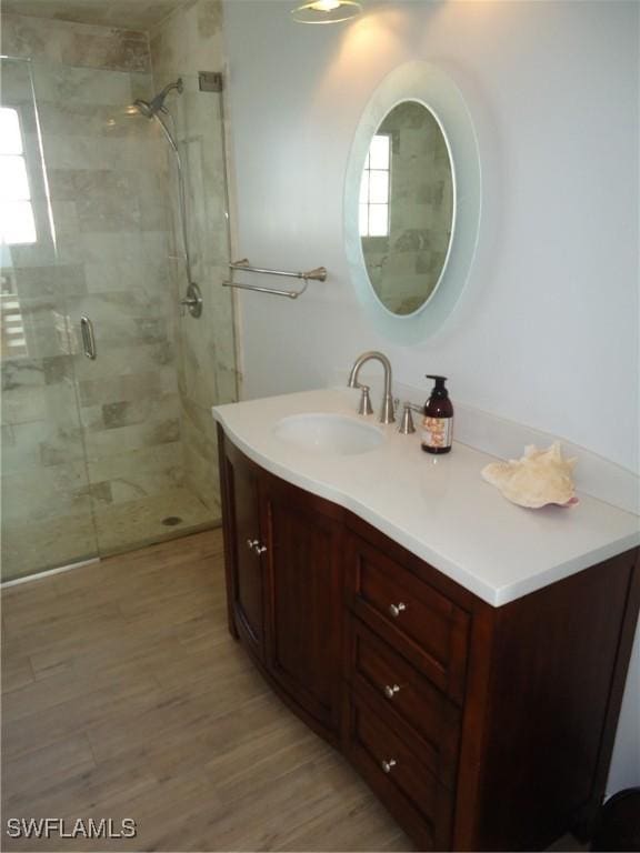 bathroom featuring vanity, wood-type flooring, and an enclosed shower