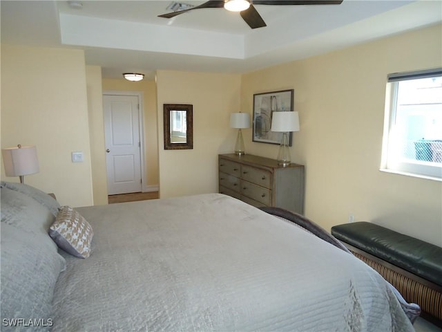 bedroom featuring ceiling fan and a raised ceiling