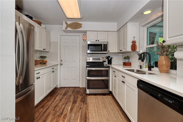 kitchen with dark wood-type flooring, decorative backsplash, white cabinetry, appliances with stainless steel finishes, and sink