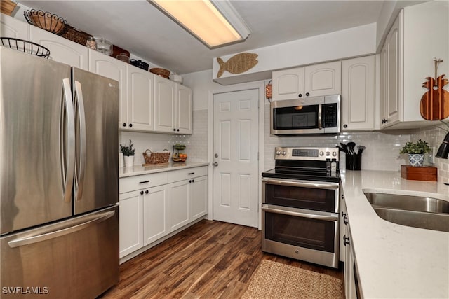 kitchen featuring sink, appliances with stainless steel finishes, backsplash, and white cabinetry