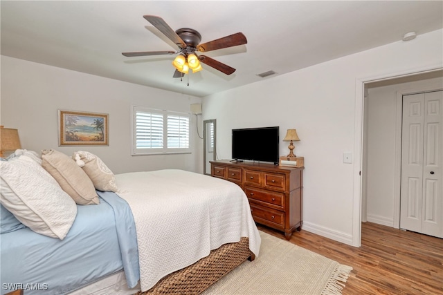 bedroom featuring ceiling fan, light wood-type flooring, and a closet