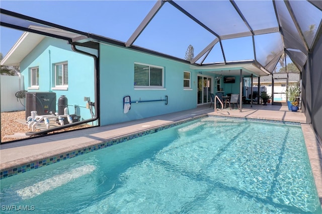 view of pool with a patio area and glass enclosure