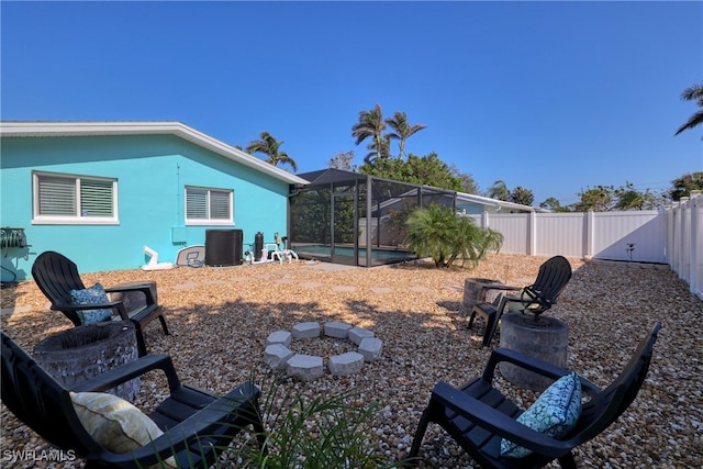 view of yard with a lanai, a fire pit, and a fenced in pool