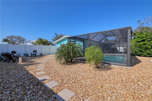 exterior space featuring a fenced in pool and glass enclosure