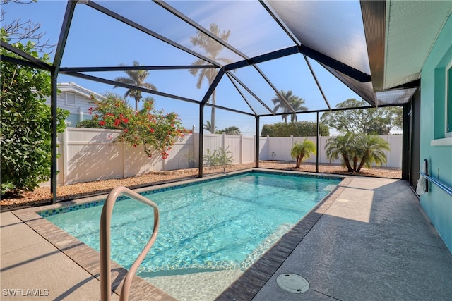 view of pool with a patio and glass enclosure