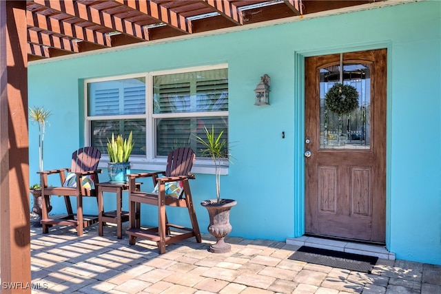 property entrance with a pergola