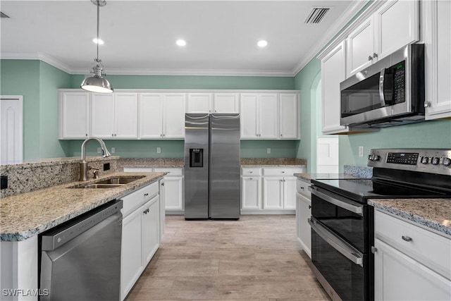 kitchen featuring white cabinetry, sink, hanging light fixtures, stainless steel appliances, and ornamental molding