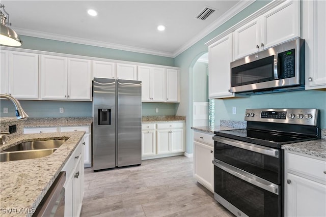 kitchen with white cabinets, ornamental molding, sink, and appliances with stainless steel finishes