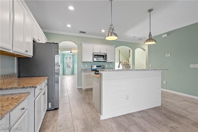 kitchen with visible vents, ornamental molding, white cabinetry, arched walkways, and appliances with stainless steel finishes