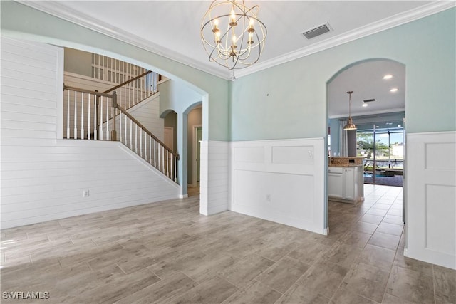 empty room featuring visible vents, a chandelier, stairs, ornamental molding, and arched walkways