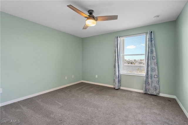 carpeted spare room featuring baseboards and ceiling fan