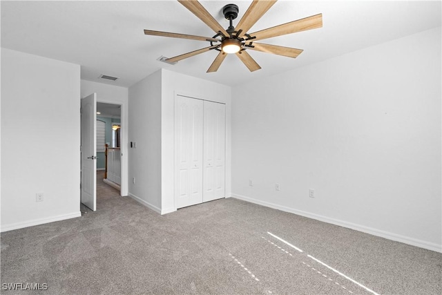 unfurnished bedroom with ceiling fan, carpet floors, and a closet