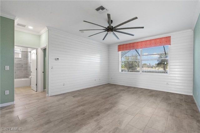 unfurnished room featuring ceiling fan, ornamental molding, and wooden walls