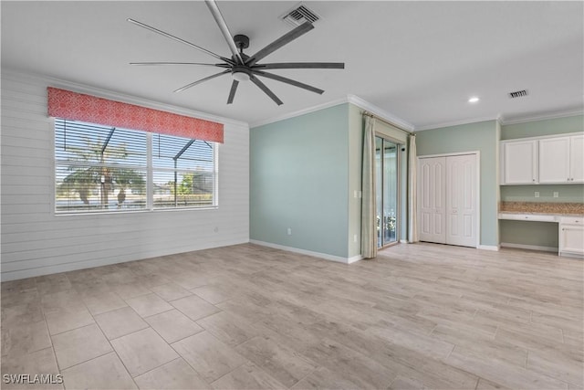 unfurnished living room featuring built in desk, ceiling fan, and crown molding