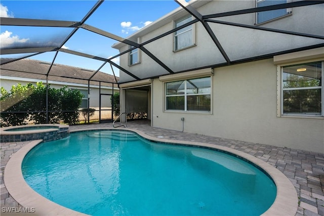 view of pool with a lanai, an in ground hot tub, and a patio